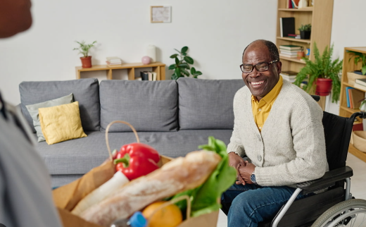 Older parent smiling as groceries and essentials are delivered at home